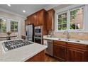 Bright kitchen featuring stainless steel appliances, hardwood floors, and a large window for natural light at 213 Old Franklin Grove Dr, Chapel Hill, NC 27514