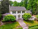 An aerial view of a beautiful two-story home with manicured lawns and surrounded by mature trees and landscaping at 220 Glandon Dr, Chapel Hill, NC 27514