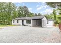 Well-maintained exterior showcasing white brick, a black roof, and a convenient carport at 2616 Wedgedale Ave, Durham, NC 27703