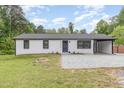 Well-maintained exterior showcasing white brick, a black roof, and a convenient carport at 2616 Wedgedale Ave, Durham, NC 27703