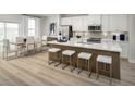 Stylish kitchen with white cabinets, stainless steel appliances, island with seating, and open dining area at 2881 Foster Woods Dr, Apex, NC 27502