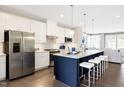 Beautiful kitchen features stainless steel appliances, a navy island with stool seating, and an open layout at 2889 Foster Woods Dr, Apex, NC 27502