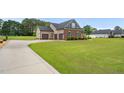 Sprawling lawn and three-car garage accentuate this brick home at 3345 Little Creek Church Rd, Clayton, NC 27520