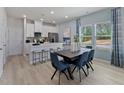 Bright dining area with modern table, chairs, and large windows offering ample natural light at 3714 Rosebush Dr, Zebulon, NC 27597