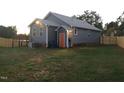 Exterior rear view featuring a spacious yard, wooden deck, and blue siding at 405 Starrett Ct, Raleigh, NC 27603