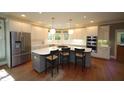 Spacious kitchen with stainless steel appliances, island with bar seating, and bright lighting, ideal for cooking at 423 Oakland Dr, Raleigh, NC 27609