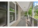 Relaxing covered front porch features neutral siding and black railings at 4420 Tetbury Pl, Raleigh, NC 27613