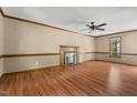 Spacious living room featuring wood floors, a ceiling fan, and a brick fireplace at 4420 Tetbury Pl, Raleigh, NC 27613