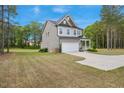 Side view of a charming two-story home with a spacious manicured lawn and a two-car garage at 4455 Old Us 421, Lillington, NC 27546