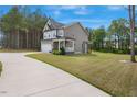 Back view of a charming two-story home with a spacious manicured lawn and attached two-car garage at 4455 Old Us 421, Lillington, NC 27546