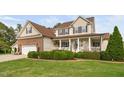 Charming two-story home boasts a manicured lawn and a welcoming front porch with manicured landscaping at 48 Falling Oak Ct, Clayton, NC 27520