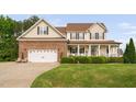 Charming two-story home with a brick-accented garage and a welcoming front porch with manicured landscaping at 48 Falling Oak Ct, Clayton, NC 27520