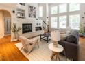 Bright living room with large windows, hardwood floors, and a cozy fireplace at 5129 Bartons Enclave Ln, Raleigh, NC 27613