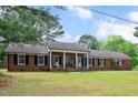 Beautiful one story red brick home with manicured lawn and charming front porch with white columns at 603 Warren Rd, Erwin, NC 28339