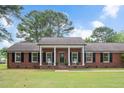 Lovely red brick home with a welcoming front porch, rocking chairs, and a spacious green lawn at 603 Warren Rd, Erwin, NC 28339