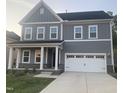 Stylish gray two-story home showcasing a modern facade, a two-car garage and a neatly kept lawn at 633 Hardin Hill Ln, Knightdale, NC 27545