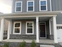 Inviting front porch with stone accents, sturdy white columns, and large windows providing natural light at 633 Hardin Hill Ln, Knightdale, NC 27545