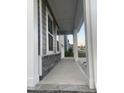 Comfortable front porch boasting stone accents, white columns, and a smooth concrete walkway at 633 Hardin Hill Ln, Knightdale, NC 27545