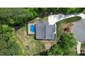 Aerial view of backyard featuring a sparkling pool, deck, and well-maintained landscaping at 66 Romie Ct, Pittsboro, NC 27312