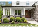 Inviting front porch with stone pillars and cozy seating area, enhancing curb appeal at 66 Romie Ct, Pittsboro, NC 27312