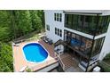 Backyard pool with deck, lounge chairs, and screened-in porch perfect for relaxation and entertainment at 66 Romie Ct, Pittsboro, NC 27312