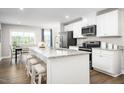 Bright kitchen featuring white cabinets, stainless steel appliances, granite countertops and eat-in island at 70 Saintsbury Dr, Fuquay Varina, NC 27526