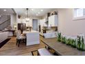Well-lit kitchen with white cabinets, island, stainless steel appliances, and hardwood floors, open to dining area at Tbd Hudson Hills Rd, Pittsboro, NC 27312