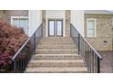 Brick stairway leads to double front doors flanked by white pillars and decorative sconces at 1004 Dunleigh Dr, Burlington, NC 27215