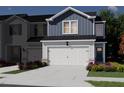 Exterior rendering of a blue and white townhome with a two-car garage and landscaped front yard at 1041 Winding Spring Dr, Mebane, NC 27302