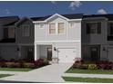 Charming two-story townhome with white siding, brick accents, a front-facing garage, and landscaping at 1047 Winding Spring Dr, Mebane, NC 27302