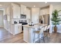 Bright, open kitchen featuring stainless steel appliances, granite countertops, white cabinets, and an island at 1049 Winding Spring Dr, Mebane, NC 27302