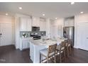 Kitchen featuring island, white cabinets, stainless steel appliances, granite counters, and barstool seating at 1053 Winding Spring Dr, Mebane, NC 27302