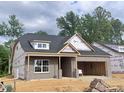 Exterior view of a new home under construction, featuring a brick facade and garage framing at 1085 Fairhaven Dr # 49, Mebane, NC 27302