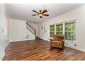 Bright living room with hardwood floors, a ceiling fan, and a comfortable chair next to a large window at 1176 Stoney Mountain Rd, Rougemont, NC 27572