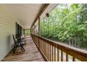 Relax on this covered porch with wood railings and plenty of space to unwind and enjoy wooded views at 1176 Stoney Mountain Rd, Rougemont, NC 27572