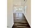 Open-concept living room features wood-look floors, bright white walls, and large windows at 136 N Keatts Winner Ct, Clayton, NC 27520