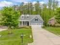 Inviting blue home with a manicured lawn, a two-car garage, and charming curb appeal at 1620 Hasentree Villa Ln, Wake Forest, NC 27587