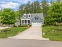 Charming blue home with a well-kept lawn, two-car garage, and inviting front yard at 1620 Hasentree Villa Ln, Wake Forest, NC 27587