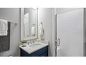 Bathroom featuring a modern vanity with quartz countertop, sleek fixtures, a walk-in shower, and contemporary finishes at 1733 Birdhaven Ln, Wendell, NC 27591