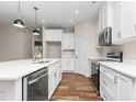 Bright kitchen featuring white cabinetry, stainless steel appliances, an island and wooden floors at 186 N Ashe Ave, Dunn, NC 28334