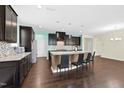 This kitchen features a large island with seating, granite countertops, and dark wood cabinets at 2008 Campana Dr, Raleigh, NC 27603