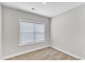 Neutral bedroom features plush carpet, a window with blinds, and fresh, neutral paint at 206 Jetson Creek Way, Youngsville, NC 27596