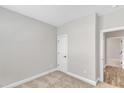 Cozy bedroom with neutral carpet, trim, and paint, with a doorway to another room at 206 Jetson Creek Way, Youngsville, NC 27596