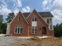 Beautiful two-story brick home with large windows and dark roof at 2590 Silas Peak Ln, Apex, NC 27523
