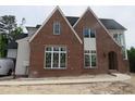 Stunning new construction featuring brick and siding, complemented by large windows and modern design elements at 2590 Silas Peak Ln, Apex, NC 27523