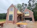 Craftsman-style brick home under construction with a side-entry garage and architectural trim at 3324 Founding Place, Raleigh, NC 27612