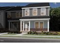 Charming two-story home with a combination of gray siding and brick accents, enhanced by lush landscaping at 3710 Rosebush Dr, Zebulon, NC 27597