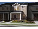 Charming townhome showcases classic design with stone accents, covered entry, and professionally landscaped front yard at 3712 Rosebush Dr, Zebulon, NC 27597