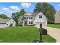 Beautiful two-story white home with black shutters, complemented by a lush green lawn and mature trees at 4418 Gallatree Ln, Raleigh, NC 27616