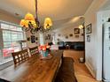 Inviting dining area with a chandelier, wood table, and view into living room and bright window at 501 Bellmeade Bay Dr, Durham, NC 27703